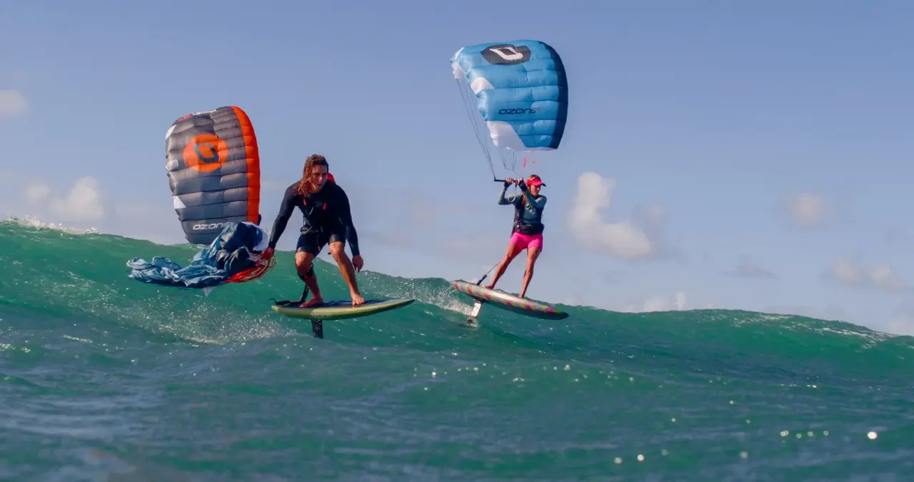 Deux riders en parawing sur une vague turquoise