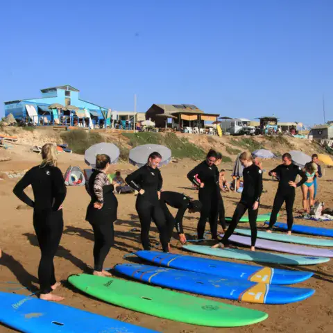 Cours collectif, planches alignées sur le sable