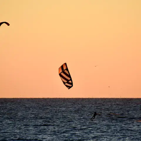 Session de kitesurf au coucher du soleil