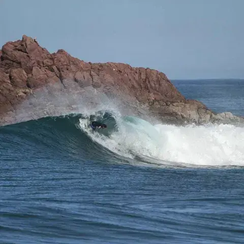 Une vague devant la pointe rocheuse