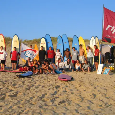 Groupe de stagiaires avec leurs planches sur la plage