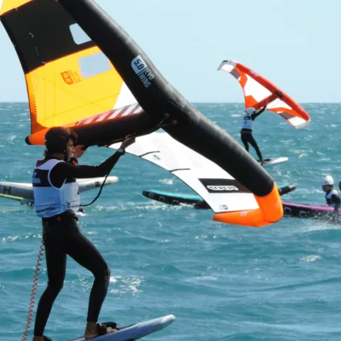 Pratiquante de wingfoil avec une aile jaune et noire