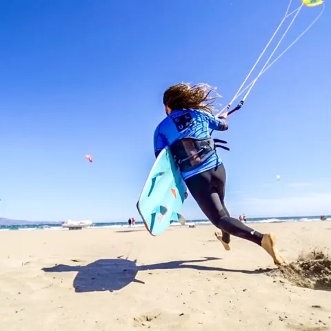 Kitesurfeuse sur la plage avec sa planche