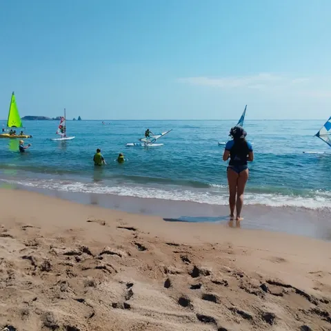 Plage avec voiliers légers sur l'eau