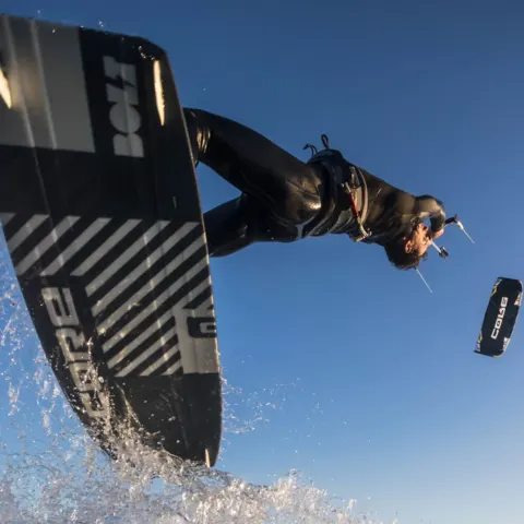 Kitesurfeur en plein saut avec sa planche