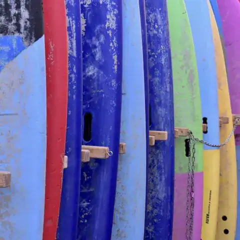 Planches de surf de l'école rangées en rack