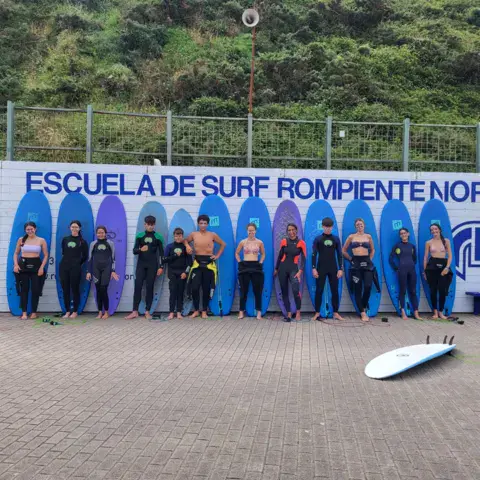 Groupe d'élèves alignés devant le mur de l'école