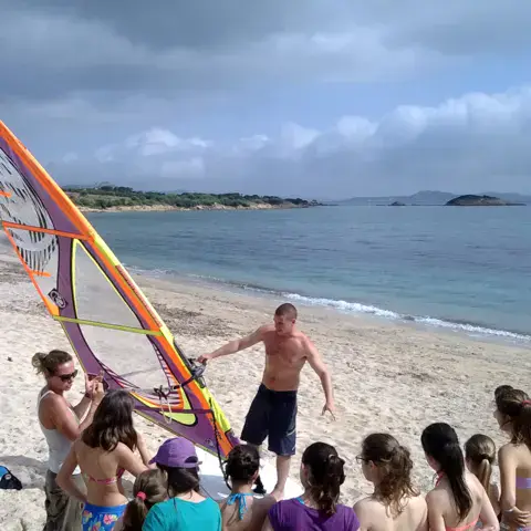 Briefing d'un cours de windsurf sur la plage