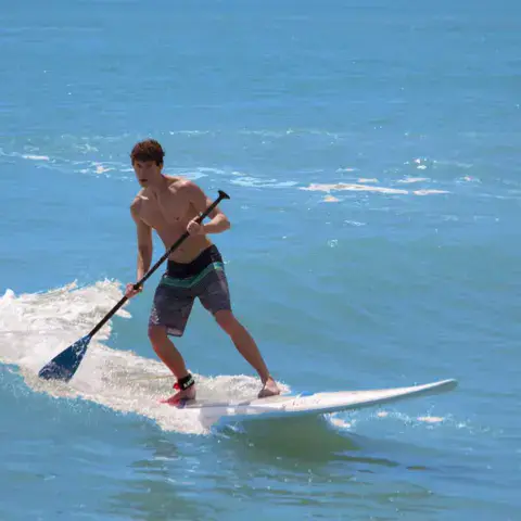 Pratique du stand up paddle sur les vaguelettes