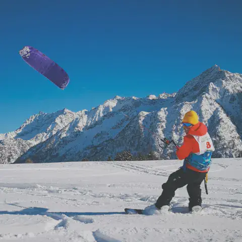Rider de snowkite devant un massif enneigé