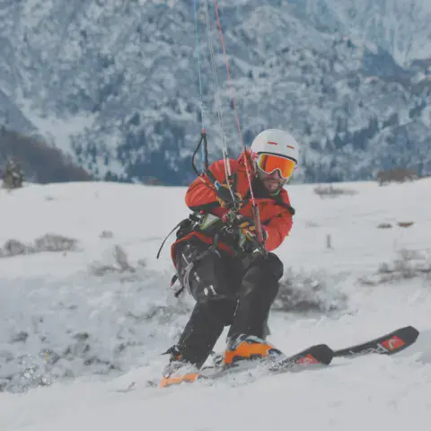Rider de snowkite à skis en montagne