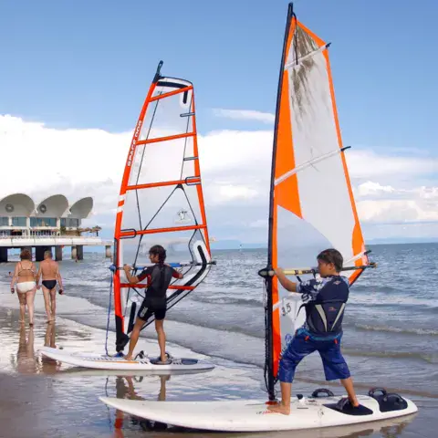 Élèves en cours de windsurf au bord de l'eau