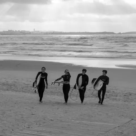 Groupe de surfeurs avec leurs planches sur la plage