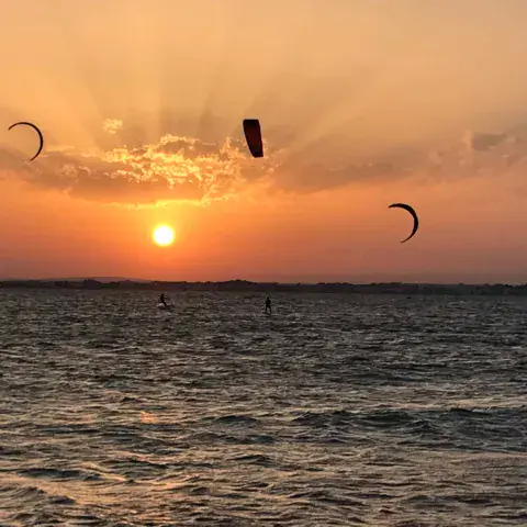 Kitesurfers au coucher du soleil