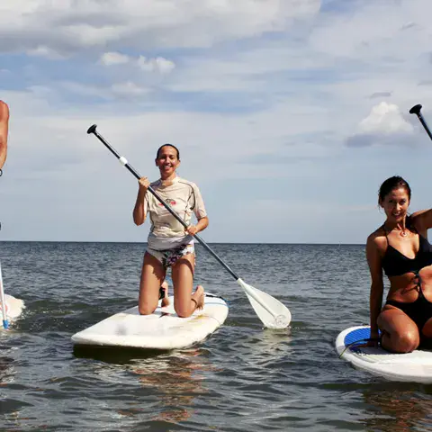 Trois pratiquants de stand up paddle sur l'eau calme
