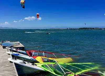 Planches et gréements amarrés au ponton, kites au loin