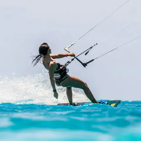 Kitesurfeuse en action sur une eau turquoise