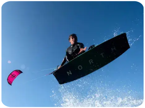 Kitesurfeur en saut sous un ciel bleu