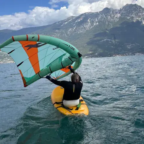 Wingfoiler sur le lac de Garde, montagnes en arrière-plan