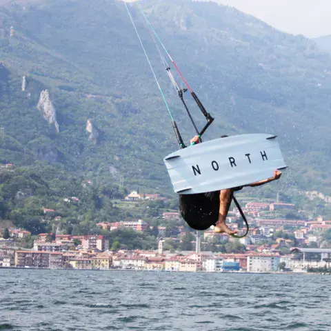 Kitesurfeur en saut devant la rive du lac d'Iseo