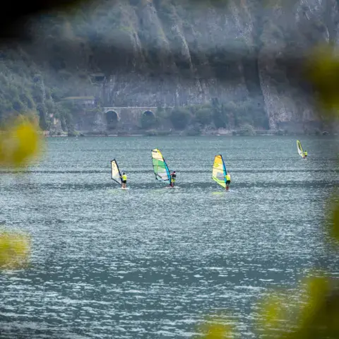Planches à voile sur le lac d'Iseo devant la rive