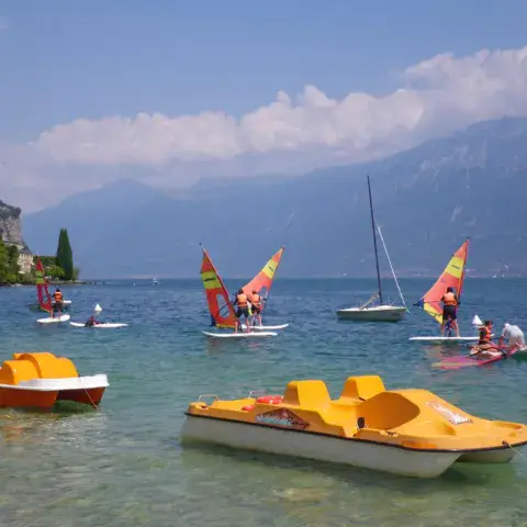 Planches à voile et pédalos sur l'eau devant le centre