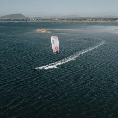 Kitesurfeur sur l'eau plate de la lagune