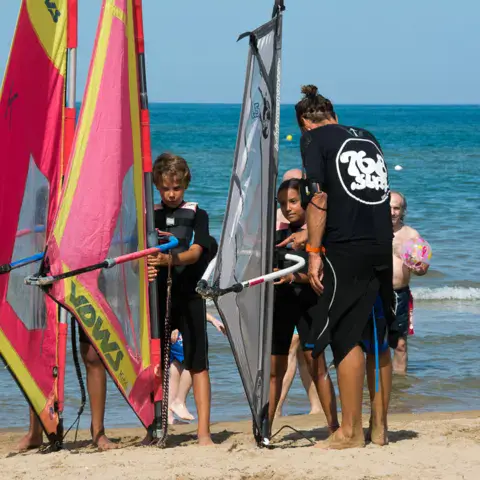 Moniteurs et élèves de windsurf sur la plage