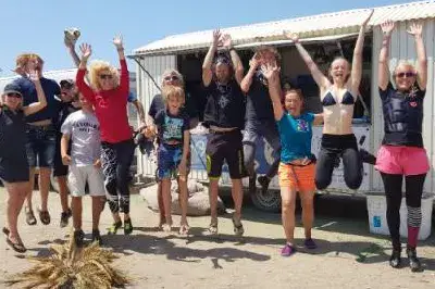Équipe et élèves réunis sur la plage devant un van