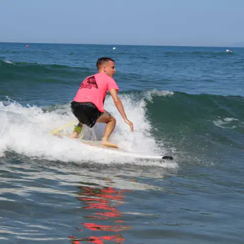 Élève de surf sur une vague