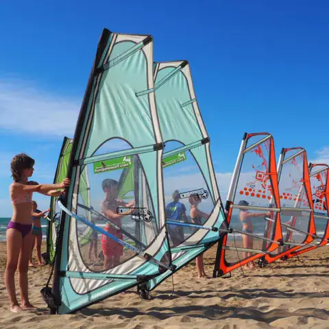 Gréements de windsurf alignés sur la plage
