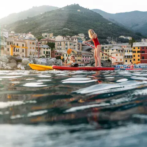 Stand up paddle devant un village côtier