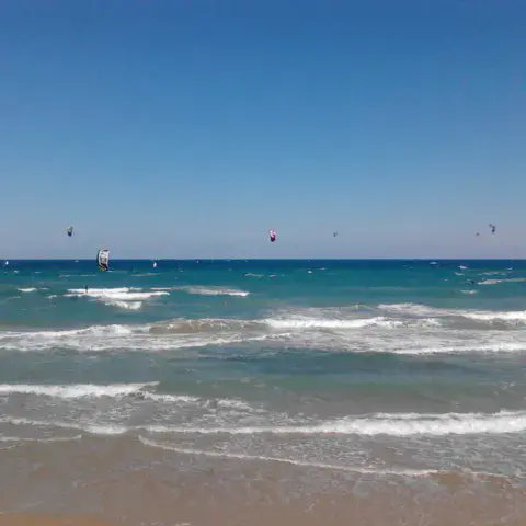 Plage avec kitesurfeurs sur l'eau