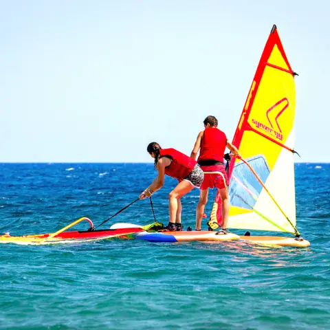 Deux élèves sur une planche à voile