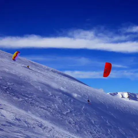 Snowkiters sur une pente
