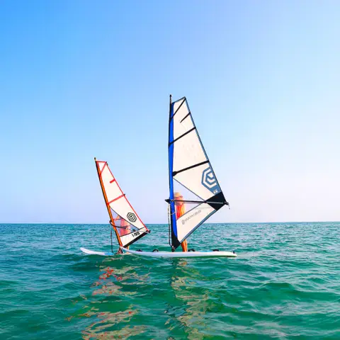 Windsurfeurs sur une eau turquoise