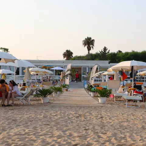 Plage aménagée avec parasols et allée