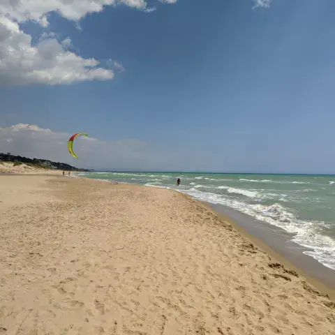 Plage de sable avec un kite dans le ciel
