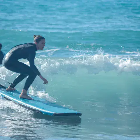 Élève de surf debout sur la planche
