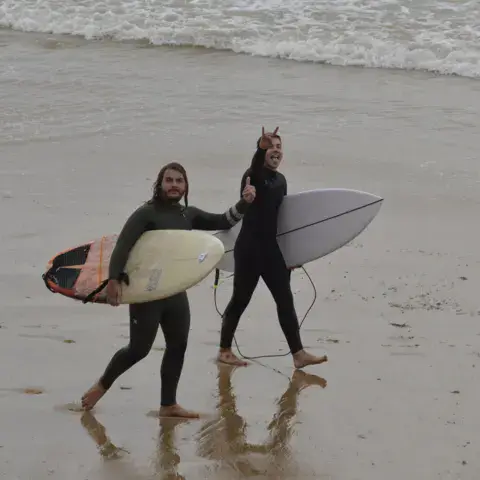 Deux surfeuses sur la plage avec leurs planches