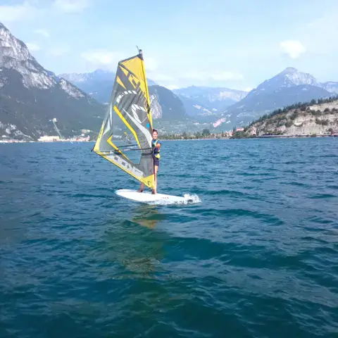 Windsurfeur sur planche large devant les montagnes