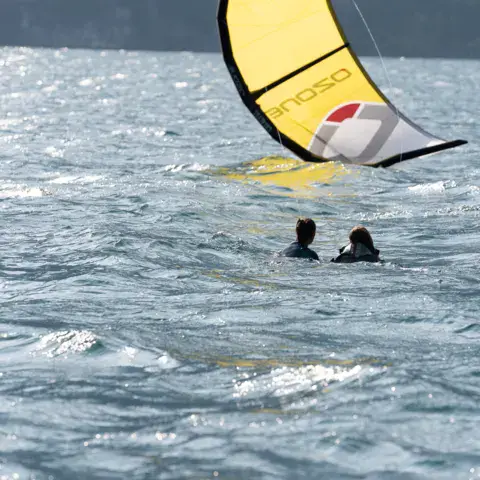 Kitesurfeurs dans l'eau avec leur aile jaune