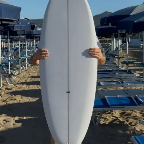 Planche de surf tenue sur la plage