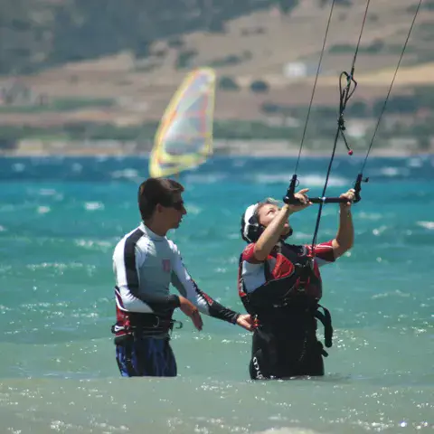 Moniteur et élève dans l'eau pendant un cours de kitesurf