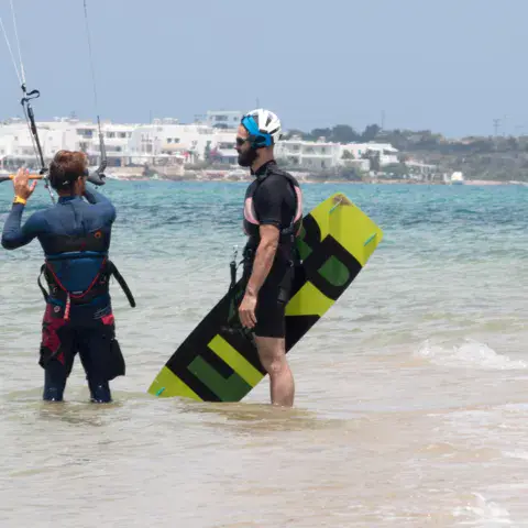 Moniteur et élève avec une planche de kite dans l'eau