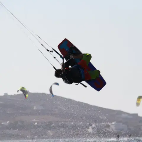 Kitesurfeur en saut devant la côte