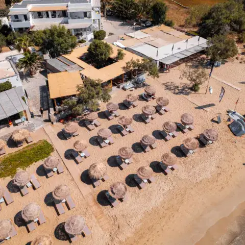 Vue aérienne de la plage avec parasols en paille et matériel nautique