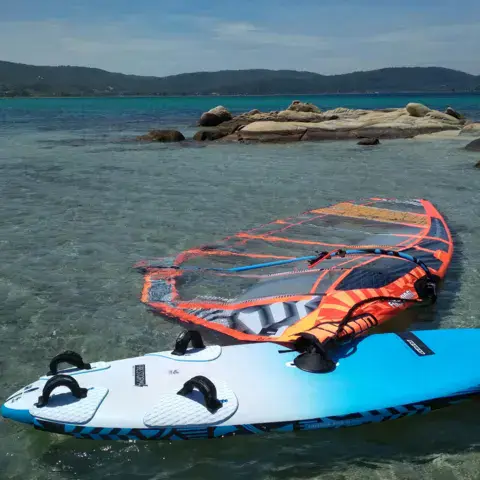 Planche et voile de windsurf dans l'eau peu profonde