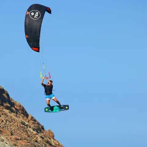 Kitesurfeur en l'air sous une aile noire