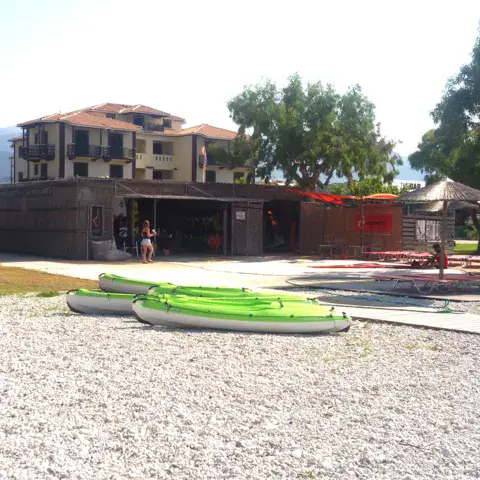 Bâtiment de la station en bord de plage, avec des kayaks au premier plan